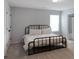 A modern bedroom with a black metal frame bed, carpet, and ensuite bathroom at 20 Geranium Ln, Covington, GA 30016
