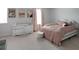 A cute bedroom with a white dresser, pink curtains, and bed with matching pink bedding at 20 Geranium Ln, Covington, GA 30016