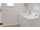 Well-lit laundry room equipped with a side-by-side washer and dryer and white shelving at 20 Geranium Ln, Covington, GA 30016