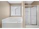 Bathroom featuring a glass-enclosed shower, a soaking tub and a window with natural light at 2967 Albright Cmns, Kennesaw, GA 30144