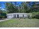 Charming single-story home features a landscaped yard, attached garage and stone accents on the facade at 3000 Kennesaw Nw Dr, Kennesaw, GA 30152