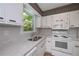 Updated kitchen featuring bright white cabinets, stone countertops, and modern appliances at 3000 Kennesaw Nw Dr, Kennesaw, GA 30152