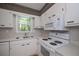 Modern white kitchen with stone countertops, contemporary appliances, and a stainless steel sink at 3000 Kennesaw Nw Dr, Kennesaw, GA 30152