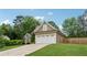 Well-maintained home featuring a two-car garage and lush landscaping on a sunny day at 1020 Regency Dr, Acworth, GA 30102