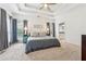 This main bedroom features a tray ceiling, a ceiling fan, carpet and a glimpse into the en suite bathroom at 1020 Regency Dr, Acworth, GA 30102