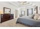 This main bedroom features carpet, a ceiling fan, tray ceiling, a sitting area and a dresser at 1020 Regency Dr, Acworth, GA 30102