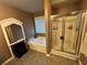 Bathroom featuring shower, tub, patterned tile, and a white frame mirror next to the tub and window at 1430 Lily Valley Dr, Lawrenceville, GA 30045