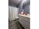This bathroom features a white shower curtain, toilet, and vanity with marble countertop and hardware at 1430 Lily Valley Dr, Lawrenceville, GA 30045