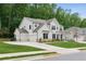 Stunning two-story white home with a three-car garage and well-manicured lawn surrounded by lush trees at 172 Aspen Hall Dr, Canton, GA 30115