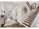 Spacious foyer with elegant staircase and stylish decor creates a welcoming entrance to the home, featuring luxury hardwood floors at 172 Aspen Hall Dr, Canton, GA 30115