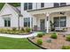 Close-up of a home's inviting front porch with seating, stylish decor, and manicured landscaping at 172 Aspen Hall Dr, Canton, GA 30115
