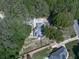 Aerial view of property with expansive backyard, fire pit, and lush surrounding trees at 173 Springwater Trce, Woodstock, GA 30188