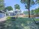 View of the house and backyard with a fire pit, covered deck, and mature trees at 173 Springwater Trce, Woodstock, GA 30188