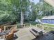 Wooden backyard deck overlooking a lush, green lawn and wooded area, perfect for outdoor dining at 173 Springwater Trce, Woodstock, GA 30188