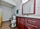 Bathroom with cherry vanity, wood look floors, and shower/tub combo at 173 Springwater Trce, Woodstock, GA 30188