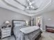 This bedroom features a tray ceiling, plush carpet, and a comfortable bed at 173 Springwater Trce, Woodstock, GA 30188