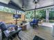 Relaxing covered patio featuring ceiling fans, TV, and comfortable seating for outdoor entertainment at 173 Springwater Trce, Woodstock, GA 30188