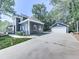 Side view of house with a long driveway leading to detached garage and basketball hoop at 173 Springwater Trce, Woodstock, GA 30188