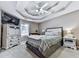 Main bedroom featuring tray ceiling, ceiling fan, large bed, and carpeted floor at 173 Springwater Trce, Woodstock, GA 30188