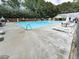 Outdoor community swimming pool with lounge chairs and tables surrounded by a secure fence at 173 Springwater Trce, Woodstock, GA 30188