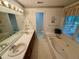 A well-lit bathroom featuring a double sink vanity, a large soaking tub, and a window for natural light at 235 Creekside Way, Mcdonough, GA 30252