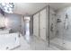 Elegant bathroom featuring a soaking tub and separate glass enclosed shower with marble tiling at 3344 Peachtree Rd # 3505, Atlanta, GA 30326