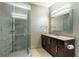 Modern bathroom with glass shower, dark wood cabinet, and large mirror with vanity lighting at 3344 Peachtree Rd # 3505, Atlanta, GA 30326