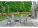 Backyard concrete patio features a seating area with a round table, five chairs, and a grill at 4170 Haynes Mill Nw Ct, Kennesaw, GA 30144
