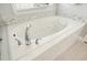Bathroom featuring soaking tub with tile surround, jets, and chrome hardware at 4170 Haynes Mill Nw Ct, Kennesaw, GA 30144