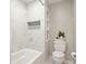 Bathroom with tiled shower, updated toilet and modern shelving at 4170 Haynes Mill Nw Ct, Kennesaw, GA 30144