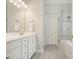Bright bathroom features double vanity, large mirror, and shower with glass door at 4170 Haynes Mill Nw Ct, Kennesaw, GA 30144