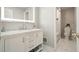 Modern bathroom vanity with white marble top, decorative mirror and ample storage at 4170 Haynes Mill Nw Ct, Kennesaw, GA 30144