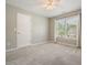 This bright bedroom features a large window with a ceiling fan and plush carpet at 4170 Haynes Mill Nw Ct, Kennesaw, GA 30144