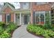 Inviting front entrance with a curved walkway, colorful landscaping, and classic columns at 4170 Haynes Mill Nw Ct, Kennesaw, GA 30144