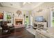 Cozy living room with a brick fireplace and large windows offering natural light at 4170 Haynes Mill Nw Ct, Kennesaw, GA 30144
