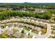 An aerial view showcasing a neighborhood with manicured lawns, mature trees, and a scenic mountain backdrop at 6995 Tybridge St, Cumming, GA 30040