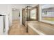 Bathroom featuring a soaking tub, tiled shower, and a view of the yard from the window at 6995 Tybridge St, Cumming, GA 30040