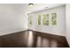Spacious bedroom with hardwood floors, large windows, and ample natural light, leading to a private patio at 6995 Tybridge St, Cumming, GA 30040