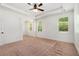 Bedroom featuring a ceiling fan, tray ceiling, and three large windows at 6995 Tybridge St, Cumming, GA 30040