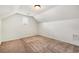 Carpeted bedroom under the roof with a window and white walls. A functional and cozy space at 6995 Tybridge St, Cumming, GA 30040