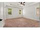 Spacious bedroom with tray ceiling, ceiling fan, and natural light from the windows at 6995 Tybridge St, Cumming, GA 30040