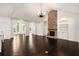 Open concept living room with a stone fireplace, built in shelving, and hardwood floors throughout at 6995 Tybridge St, Cumming, GA 30040