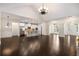Open-concept living space with hardwood floors, a modern kitchen, dining area, and great natural light at 6995 Tybridge St, Cumming, GA 30040