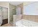 Bright bathroom showcasing a glass shower, soaking tub, and neutral tile at 2760 Lions Gate Dr, Cumming, GA 30041