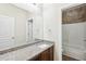 Bathroom featuring a granite countertop, a shower, and a large mirror at 2760 Lions Gate Dr, Cumming, GA 30041