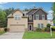 Two-story home with a two-car garage, manicured lawn, and mature landscaping at 2760 Lions Gate Dr, Cumming, GA 30041
