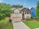 View of a two-story house with a two-car garage and a landscaped yard at 2760 Lions Gate Dr, Cumming, GA 30041