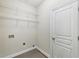 Well-lit laundry room includes white wire shelves, baseboards, and a white door at 2760 Lions Gate Dr, Cumming, GA 30041