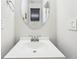 Cozy powder room features a round mirror, sink, and vanity with white walls at 2760 Lions Gate Dr, Cumming, GA 30041