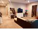 Spacious living room with neutral carpet, a large TV, and access to other rooms at 305 Anise Ct, Mcdonough, GA 30252
